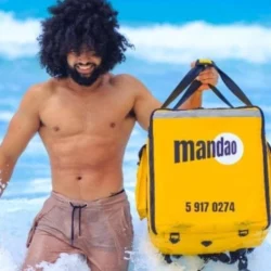 Hombre joven cubano con mochila de mAndao delivery service en la playa de Varadero, matanzas, Cuba.