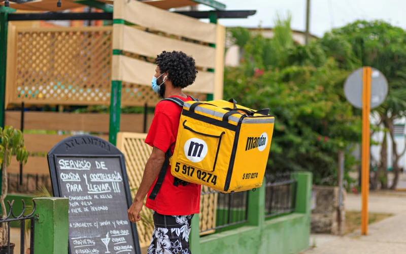 Mandadero llevando delivery en mochila amarilla de Mandao en la ciudad de Matanzas, Cuba. 