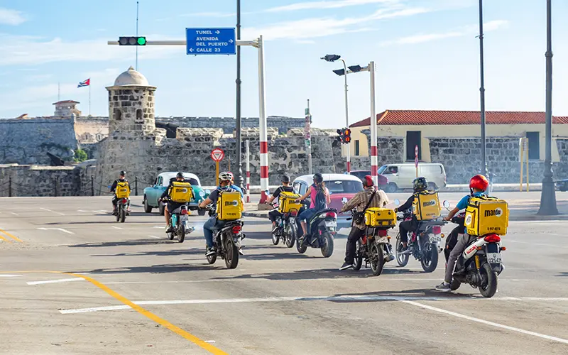 Motos con Mochilas Mandao en la calle frente al Morro en La Habana.